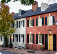 A row of brick townhomes lines a small-town street.